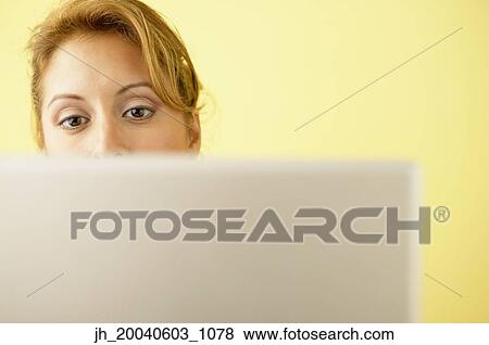 Young woman working on a laptop View Large Photo Image Stock Photo - Young woman working on a laptop. Fotosearch