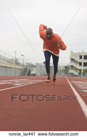 Stock Image - Athlete running on the running track. Fotosearch