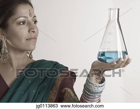 Close-up of a mid adult woman holding a flask with chemical View Large Photo Image Stock Image - Close-up of a mid adult woman holding a flask with chemical. Fotosearch