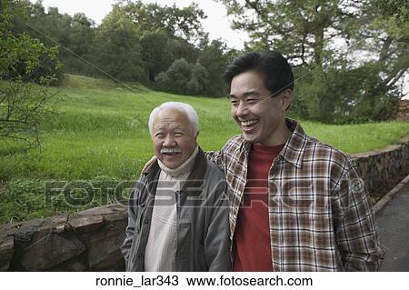 Father and his son walking together on a hillside road View Large Photo Image Stock Image - Father and his son walking together on a hillside road. Fotosearch