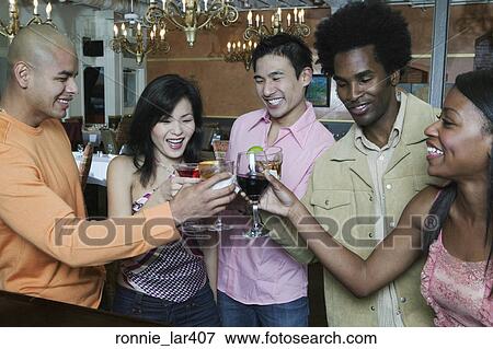 Group of people toasting glasses of wine in a nightclub View Large Photo Image Stock Photo - Group of people toasting glasses of wine in a nightclub. Fotosearch