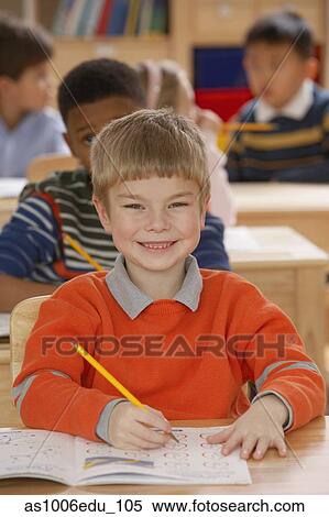 Stock Photography - Portrait of a boy smiling in a classroom. Fotosearch