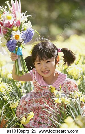 Portrait of a girl holding a bouquet of flowers in a field View Large Photo Image Stock Photography - Portrait of a girl holding a bouquet of flowers in a field. Fotosearch
