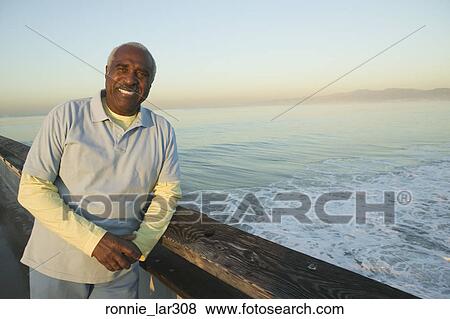 Portrait of a mature man leaning against railing on a bridge View Large Photo Image Stock Photo - Portrait of a mature man leaning against railing on a bridge. Fotosearch