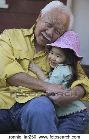 Portrait of a senior man embracing his granddaughter View Large Photo Image Stock Photography - Portrait of a senior man embracing his granddaughter. Fotosearch - Search Stock Photos, Pictures, Wall Murals, Images, and Photo Clipart