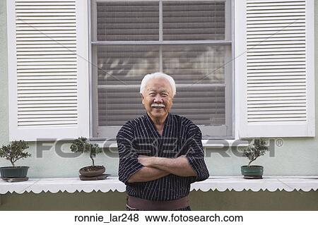 Portrait of a senior man standing with his arms crossed View Large Photo Image Stock Photo - Portrait of a senior man standing with his arms crossed. Fotosearch