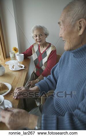 Stock Photo - Senior couple sitting together and having breakfast. Fotosearch