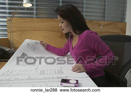 Side profile of a businesswoman looking at blueprints in an office View Large Photo Image Stock Photo - Side profile of a businesswoman looking at blueprints in an office. Fotosearch