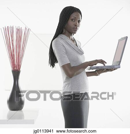 Side profile of a mid adult woman using a laptop View Large Photo Image Stock Image - Side profile of a mid adult woman using a laptop. Fotosearch