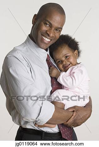 Businessman holding his baby daughter View Large Photo Image Picture - Businessman holding his baby daughter. Fotosearch