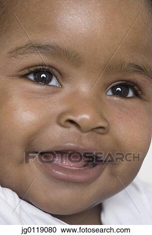 Stock Image - Close up of baby's smiling face. Fotosearch