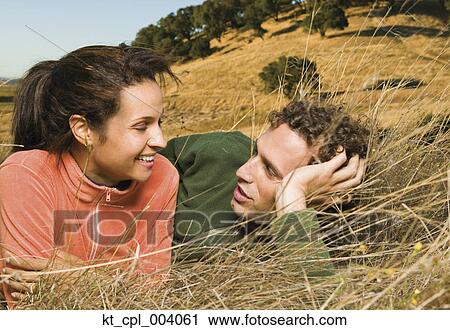 Couple laying in grass together View Large Photo Image Stock Image - Couple laying in grass together. Fotosearch