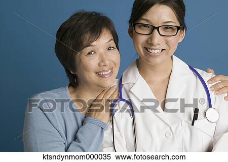 Doctor posing for the camera with her mother View Large Photo Image Stock Photography - Doctor posing for the camera with her mother. Fotosearch