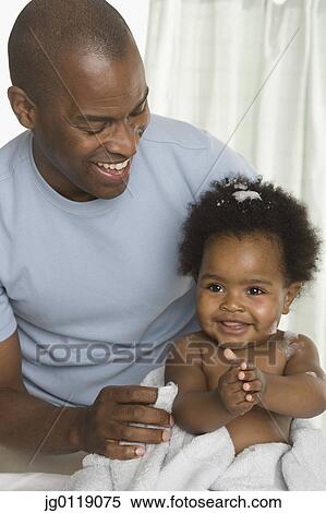 Stock Photography - Father giving his baby daughter a bath. Fotosearch