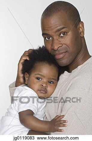 Stock Image - Father holding his baby daughter. Fotosearch