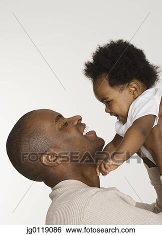 Stock Photograph - Father playing with his baby daughter. Fotosearch