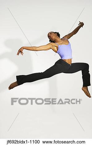 Stock Image - Female dancer leaping through the air. Fotosearch