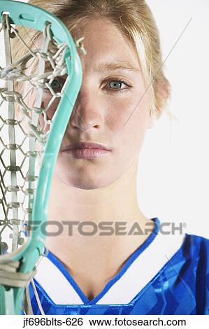Stock Photograph - Female lacrosse player holding lacrosse stick. Fotosearch
