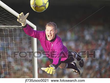 Male goalie reaching for the ball in midair View Large Photo Image Stock Image - Male goalie reaching for the ball in midair. Fotosearch