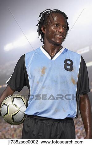 Stock Image - Male soccer player holding the ball. Fotosearch