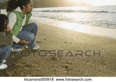 Mother and son sitting at the beach View Large Photo Image Stock Photo - Mother and son sitting at the beach. Fotosearch