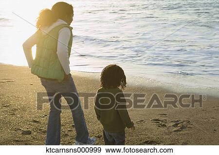 Mother and son walking on the beach View Large Photo Image Stock Photo - Mother and son walking on the beach. Fotosearch