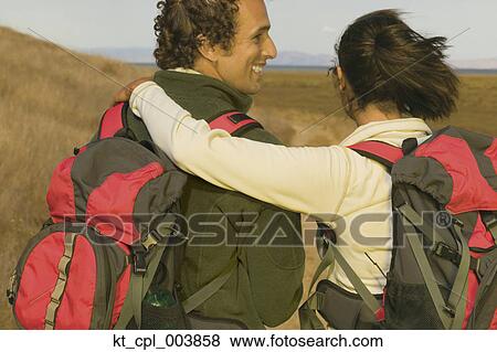 Rear view of couple hiking View Large Photo Image Stock Photo - Rear view of couple hiking. Fotosearch