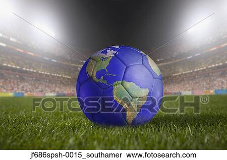 Soccer ball painted like a globe resting on grass in large stadium View Large Photo Image Stock Photography - Soccer ball painted like a globe resting on grass in large stadium. Fotosearch