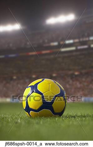 Soccer ball resting on grass in large stadium View Large Photo Image Stock Image - Soccer ball resting on grass in large stadium. Fotosearch