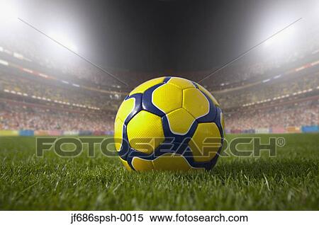 Soccer ball resting on grass in large stadium View Large Photo Image Stock Photography - Soccer ball resting on grass in large stadium. Fotosearch