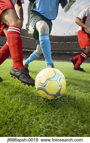 Stock Photo - Soccer players chasing the ball. Fotosearch