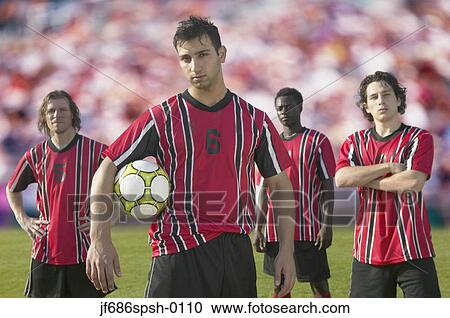 Stock Image - Soccer players posing for the camera on pitch. Fotosearch