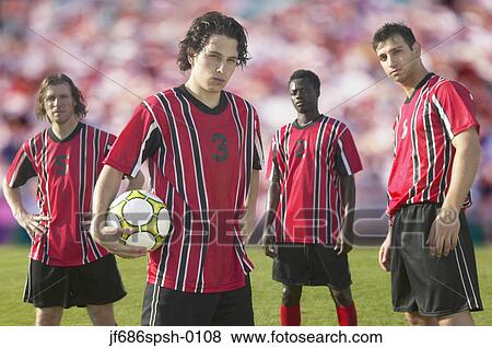 Soccer players posing for the camera on pitch View Large Photo Image Stock Photo - Soccer players posing for the camera on pitch. Fotosearch