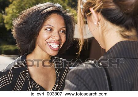 Stock Photo - Two businesswomen talking. Fotosearch