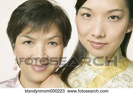 Young Asian woman and her mother in traditional clothes posing for the camera View Large Photo Image Stock Image - Young Asian woman and her mother in traditional clothes posing for the camera. Fotosearch