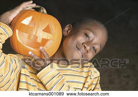Young boy smiling for the camera with a jack o lantern View Large Photo Image Stock Photo - Young boy smiling for the camera with a jack o lantern. Fotosearch