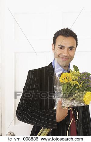 Young businessman holding a bunch of flowers View Large Photo Image Stock Photograph - Young businessman holding a bunch of flowers. Fotosearch