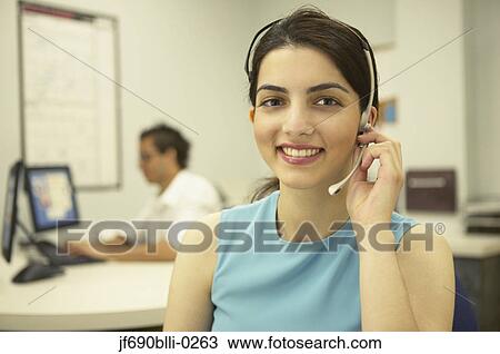 Stock Image - Young businesswoman talking on a headset. Fotosearch