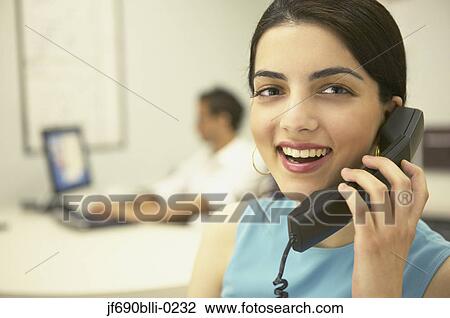 Stock Image - Young businesswoman talking on the phone. Fotosearch