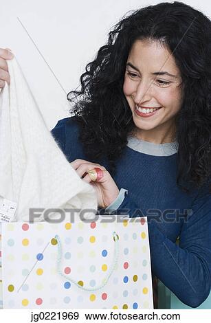 Young woman admiring new purchase View Large Photo Image Stock Photo - Young woman admiring new purchase. Fotosearch
