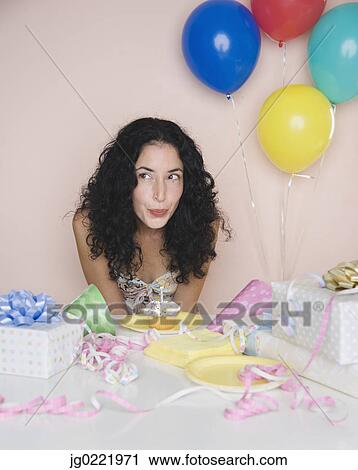 Young woman blowing out candle on birthday cupcake View Large Photo Image Stock Image - Young woman blowing out candle on birthday cupcake. Fotosearch