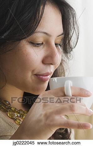 Stock Photography - Young woman drinking a cup of coffee. Fotosearch