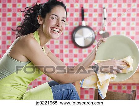 Stock Photography - Young woman drying a plate. Fotosearch