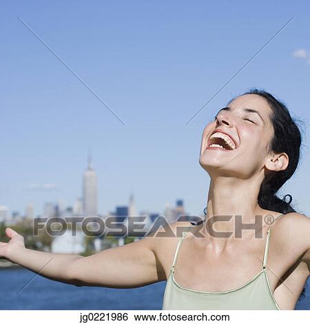 Young woman laughing with outstretched arms View Large Photo Image Stock Photograph - Young woman laughing with outstretched arms. Fotosearch