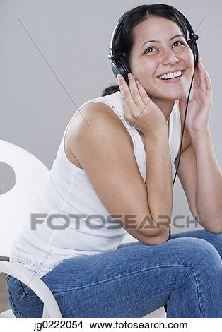 Young woman listening to headphones View Large Photo Image Picture - Young woman listening to headphones. Fotosearch