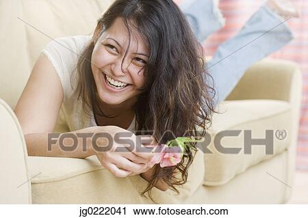 Young woman relaxing on couch and laughing View Large Photo Image Stock Image - Young woman relaxing on couch and laughing. Fotosearch