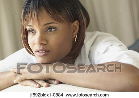 Young woman resting her chin on hands while thinking View Large Photo Image Picture - Young woman resting her chin on hands while thinking. Fotosearch