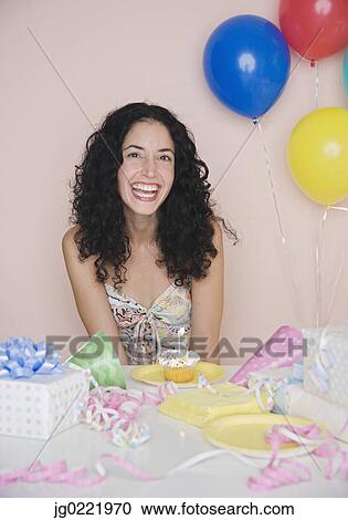 Young woman smiling for the camera at her birthday party View Large Photo Image Stock Image - Young woman smiling for the camera at her birthday party. Fotosearch