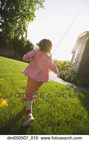 Stock Image - Back of girl running in back yard. Fotosearch