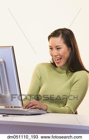 Businesswoman laughing while typing at computer View Large Photo Image Stock Image - Businesswoman laughing while typing at computer. Fotosearch